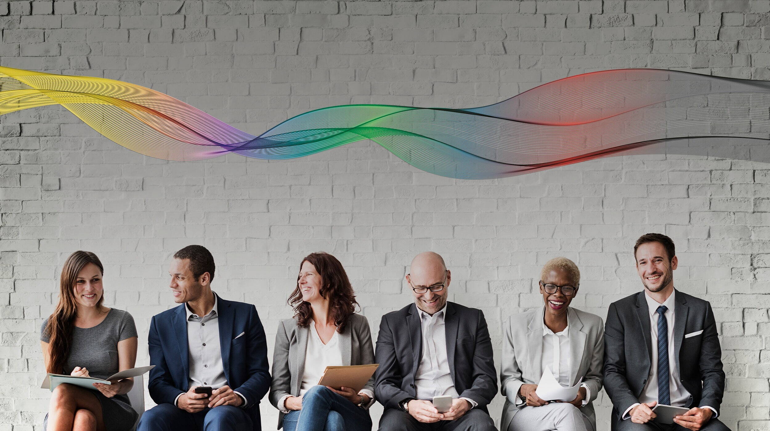 Group of candidates sat against a wall waiting for interview